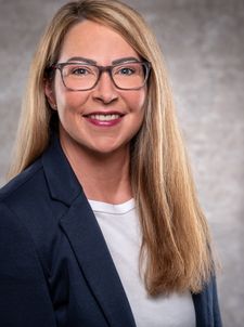 Lächelnde Frau mit Brille und langem blondem Haar